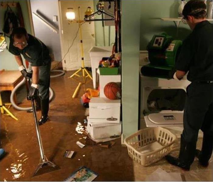 Water flooded in an utility room, wet items, technician with vacuum extractor in Auburn, WA