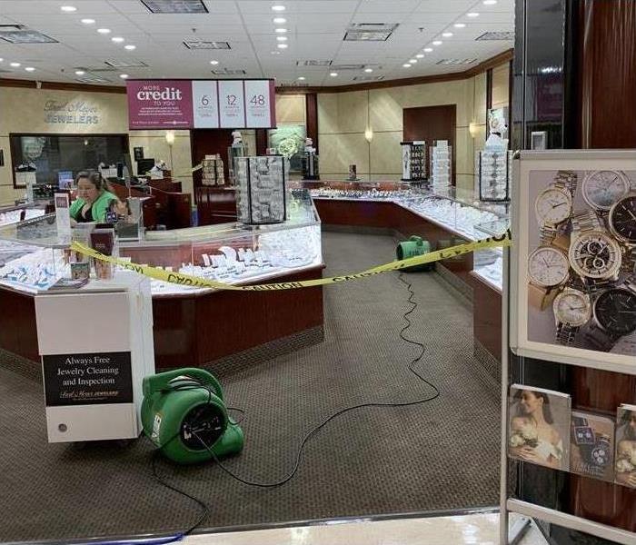 wet carpet in a jewelry store, drying equipment placed on store